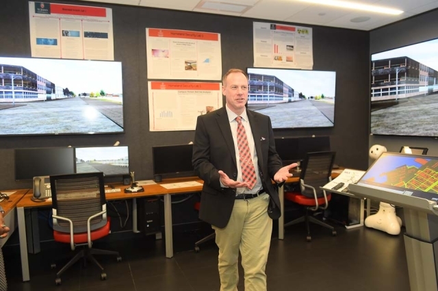 Man speaking at front of cyber security lab